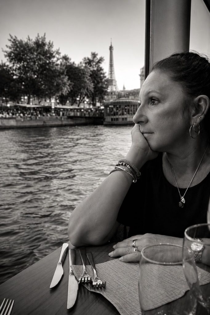 Portrait noir et blanc de Catherine Durbec, auteure du nénuphar, à Paris. Vue sur la tour Eiffel de la Seine.
